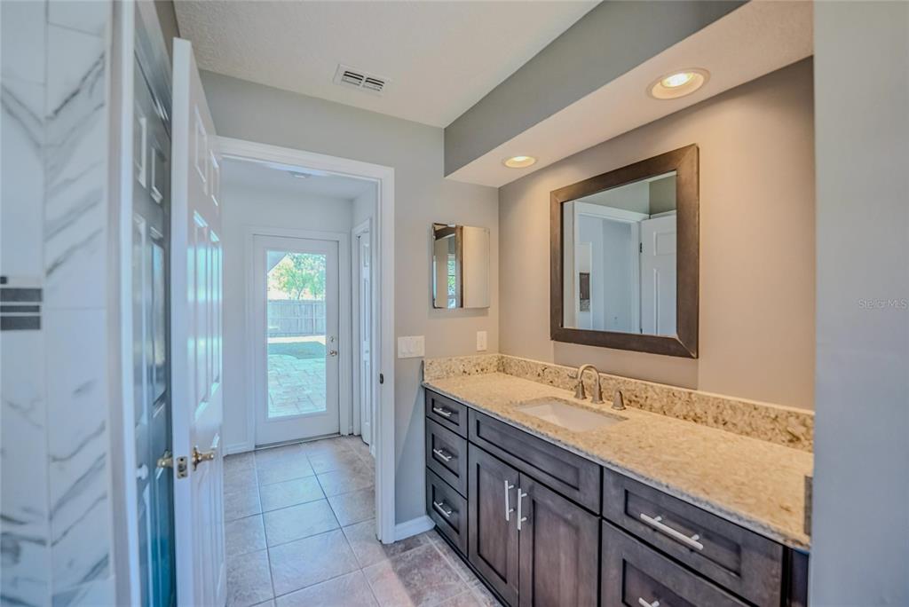 6598 Southeast 11th Loop Ocala, FL 34472 - Photo 21 of 49 a bathroom with a granite countertop sink and a mirror