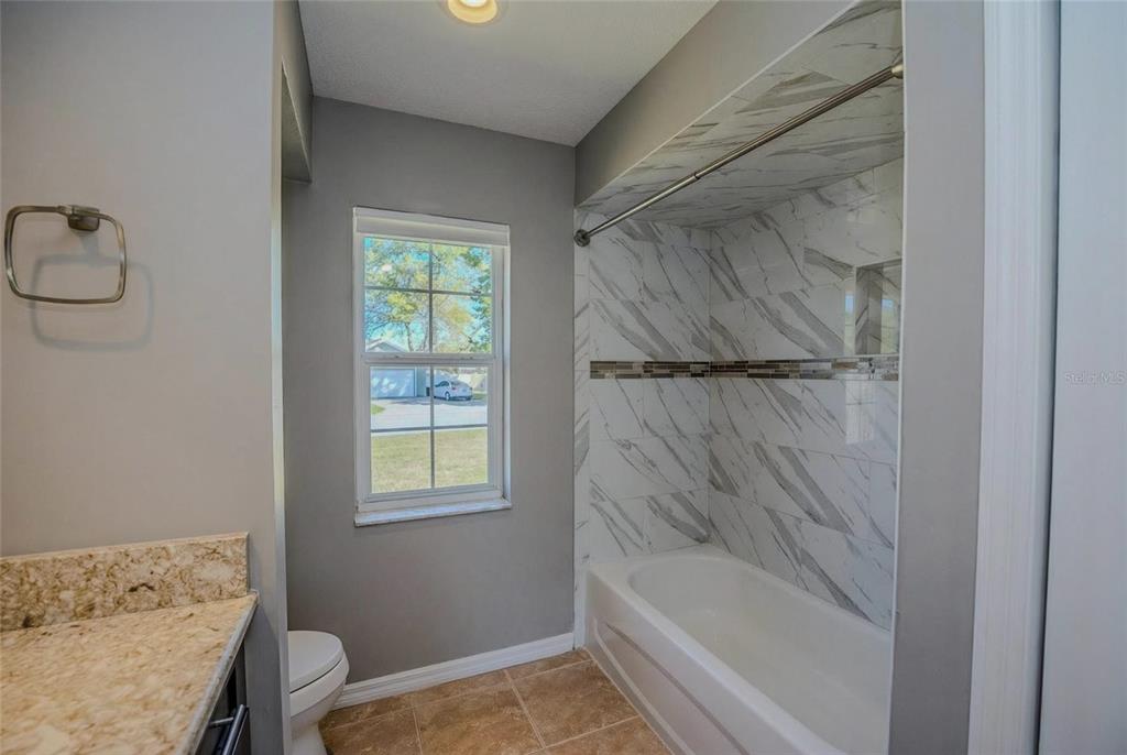 6598 Southeast 11th Loop Ocala, FL 34472 - Photo 22 of 49 a bathroom with a bathtub and shower