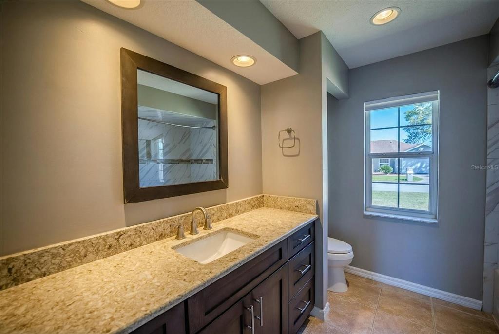 6598 Southeast 11th Loop Ocala, FL 34472 - Photo 23 of 49 a bathroom with a granite countertop sink and a mirror