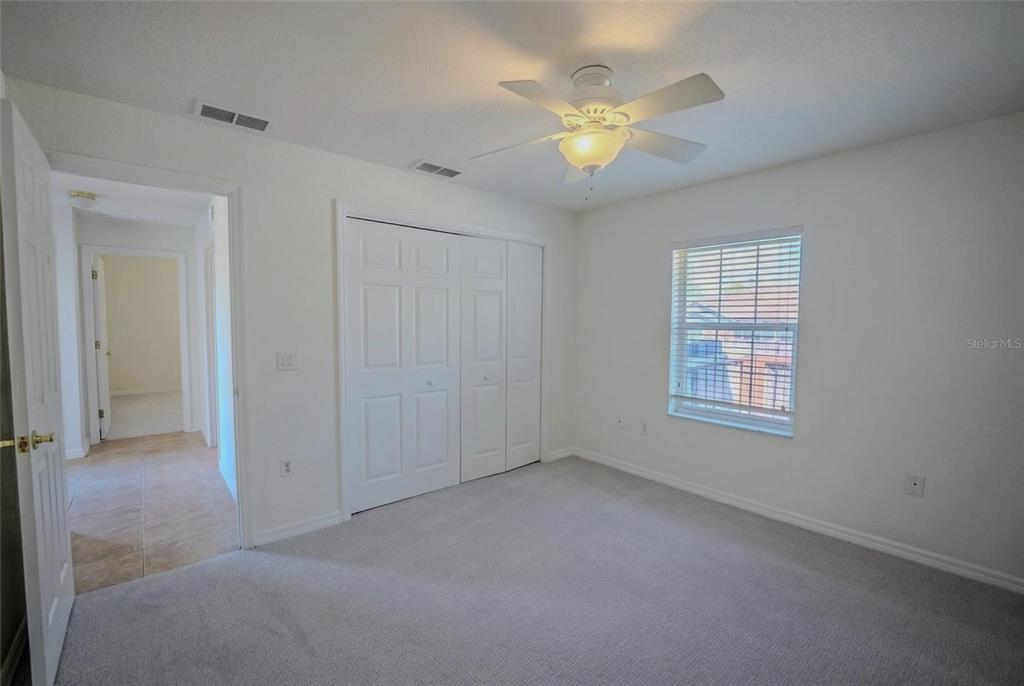 6598 Southeast 11th Loop Ocala, FL 34472 - Photo 25 of 49 an empty room with a chandelier fan and windows