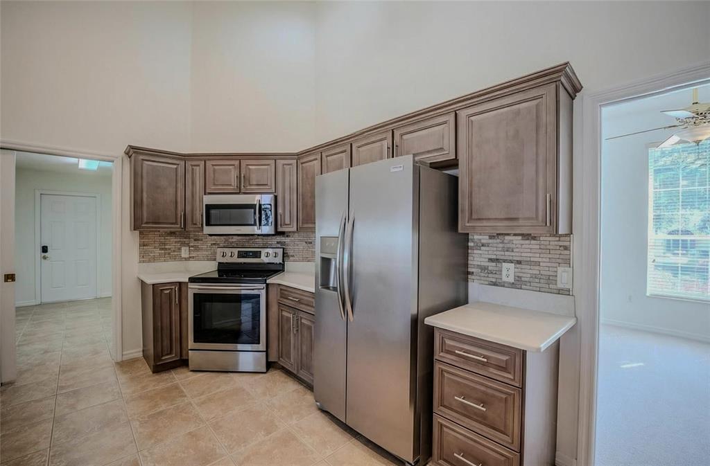 6598 Southeast 11th Loop Ocala, FL 34472 - Photo 33 of 49 a kitchen with stainless steel appliances granite countertop a refrigerator and a stove top oven