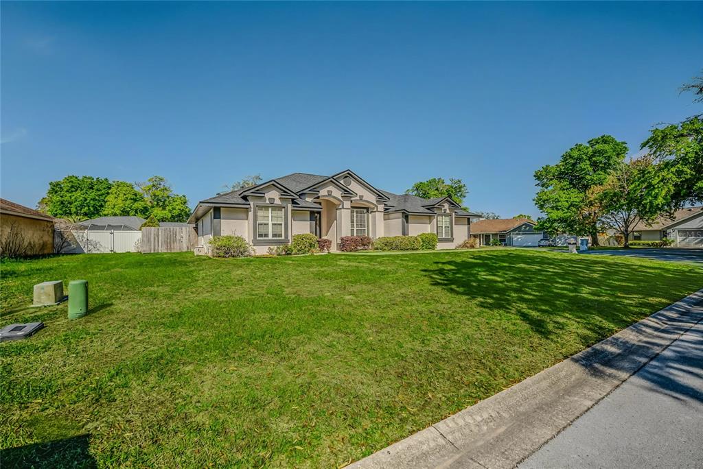 6598 Southeast 11th Loop Ocala, FL 34472 - Photo 44 of 49 a view of a house with a small yard and a garden