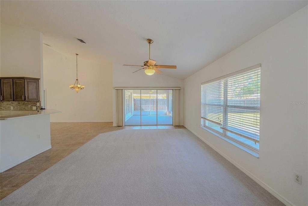 6598 Southeast 11th Loop Ocala, FL 34472 - Photo 6 of 49 a big room with windows and chandelier fan
