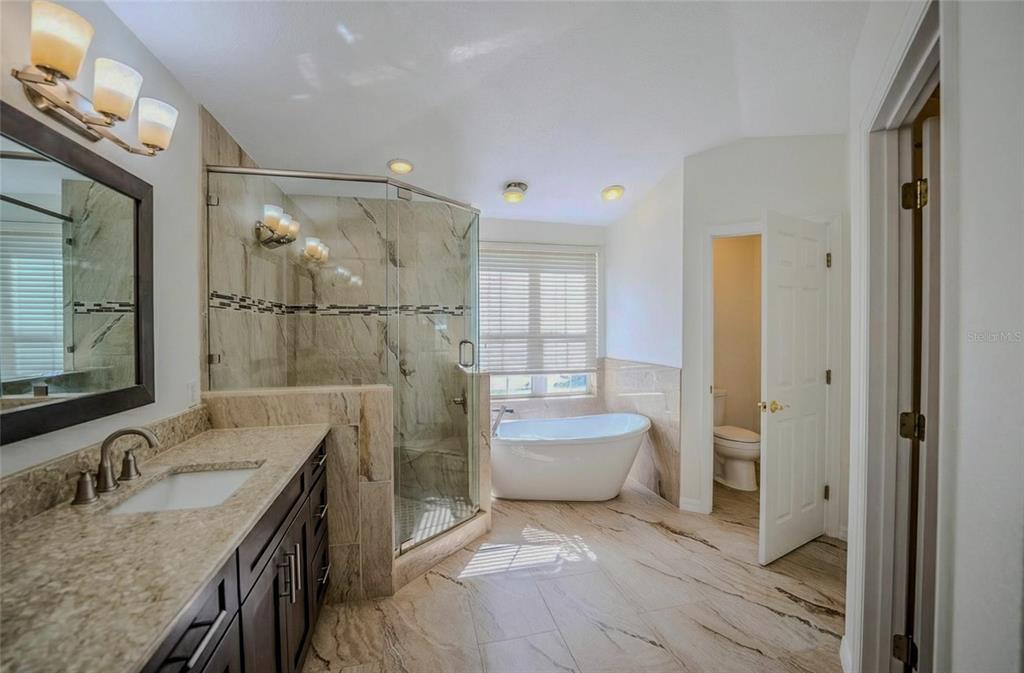 6598 Southeast 11th Loop Ocala, FL 34472 - Photo 9 of 49 a spacious bathroom with a granite countertop sink mirror and toilet