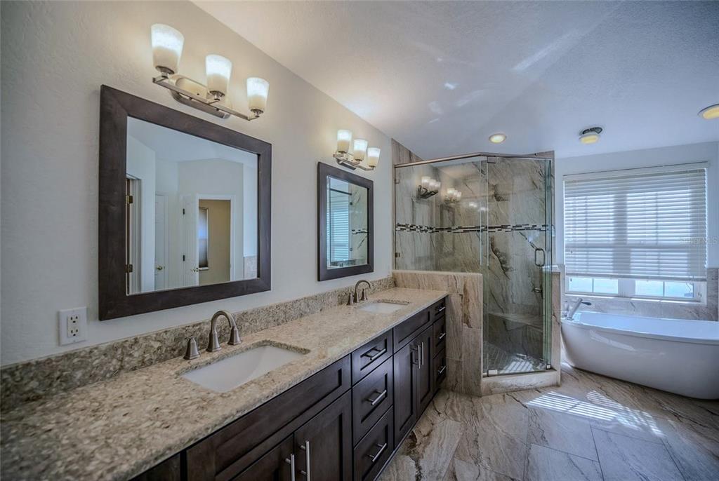 6598 Southeast 11th Loop Ocala, FL 34472 - Photo 10 of 49 a bathroom with a granite countertop double vanity sink a mirror and shower