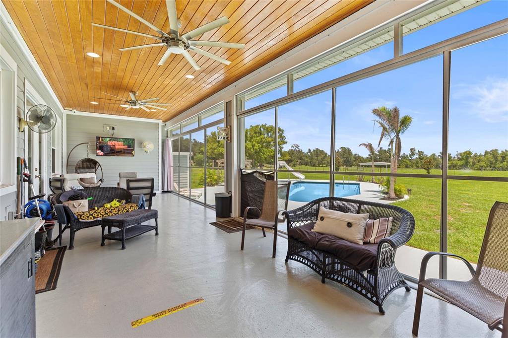 15710 Colding Loop Wimauma, FL 33598 - Photo 31 of 41 a living room with furniture and floor to ceiling windows