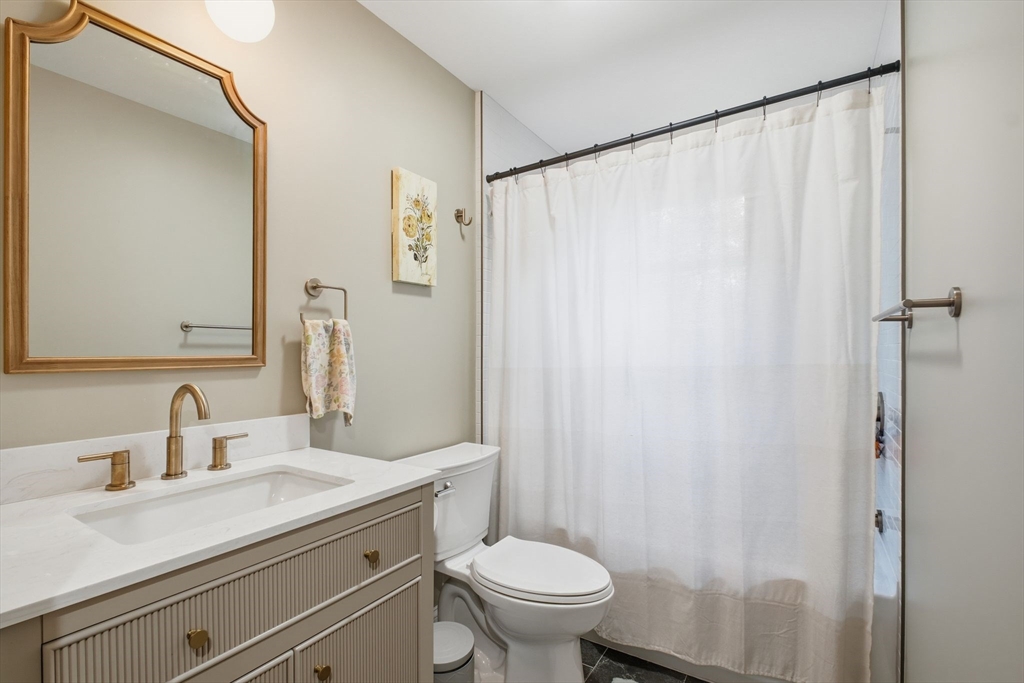 382 North Brook Road Springfield, MA 01119 - Photo 19 of 31 a bathroom with a sink a toilet a mirror and shower curtain