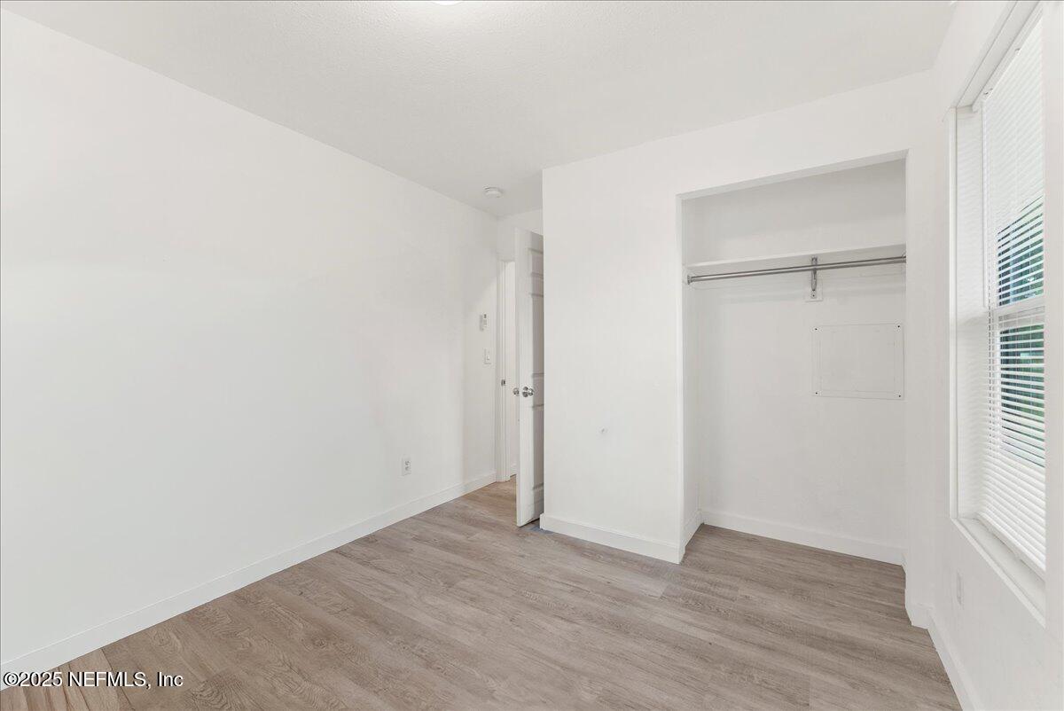 9034 Crystal Springs Road Jacksonville, FL 32221 - Photo 15 of 34 a view of an empty room with wooden floor and a window