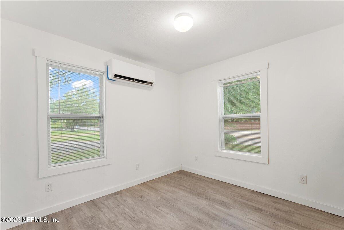 9034 Crystal Springs Road Jacksonville, FL 32221 - Photo 16 of 34 an empty room with wooden floor and windows