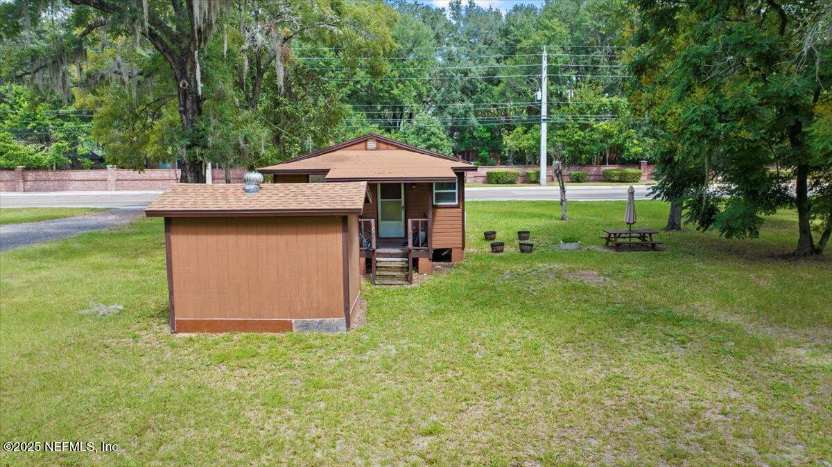 9034 Crystal Springs Road Jacksonville, FL 32221 - Photo 26 of 34 a backyard of a house with table and chairs