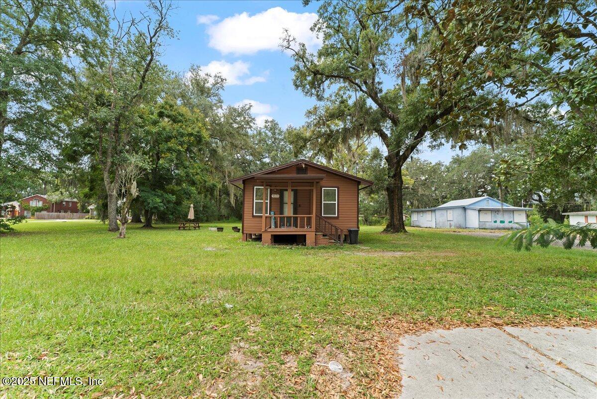 9034 Crystal Springs Road Jacksonville, FL 32221 - Photo 29 of 34 a yellow house sitting in middle of the green field