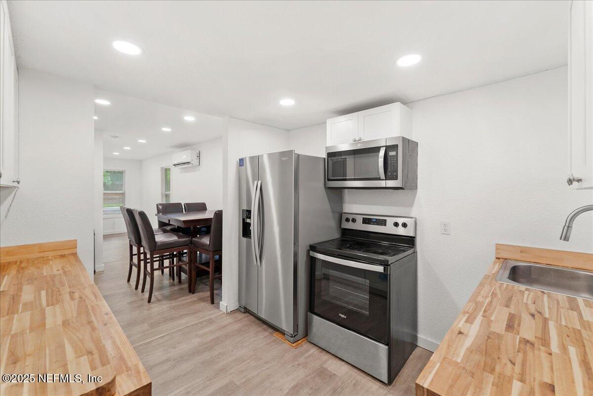 9034 Crystal Springs Road Jacksonville, FL 32221 - Photo 3 of 34 a kitchen with granite countertop a refrigerator and a stove top oven