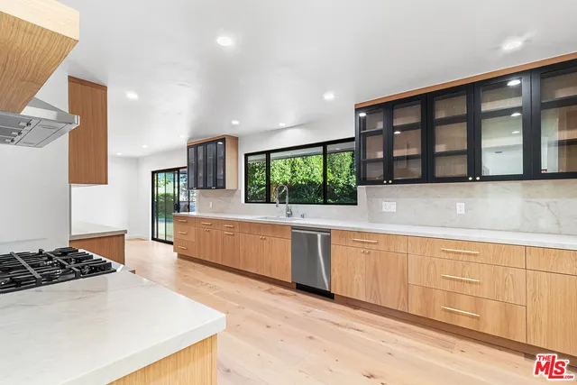 a large kitchen with stainless steel appliances granite countertop a large window and a counter space