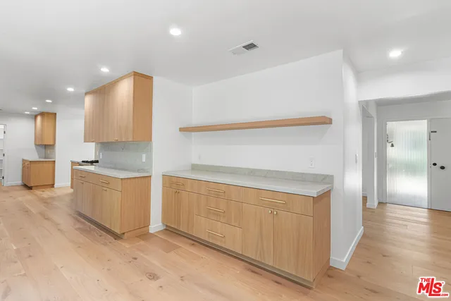a kitchen with white cabinets and sink