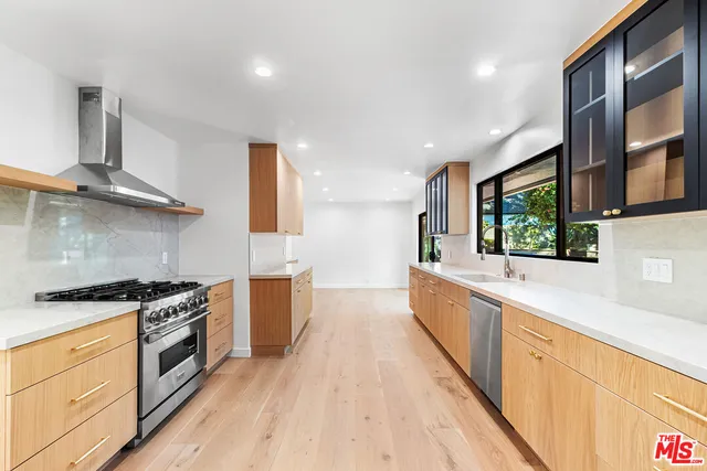 a large kitchen with stainless steel appliances granite countertop a stove a sink and a microwave