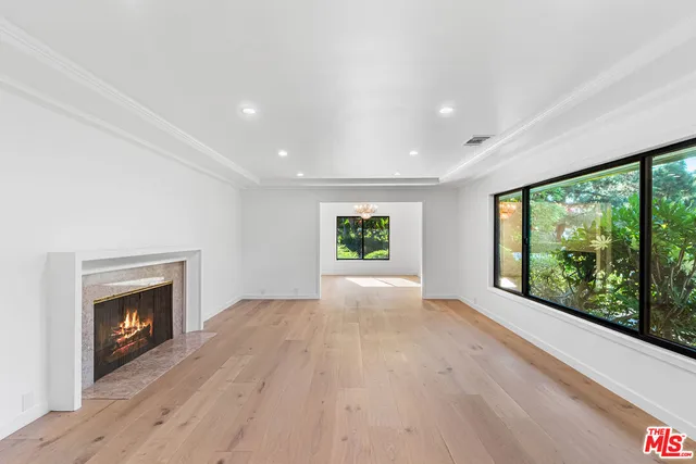 a view of empty room with wooden floor and fireplace