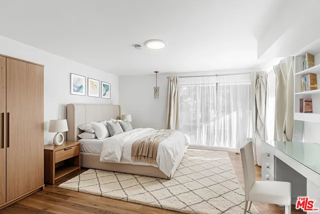 a bedroom with a bed and a large window