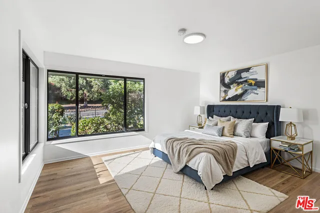 a bedroom with a bed and a large window