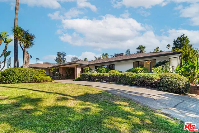 a view of a house with pool and a garden