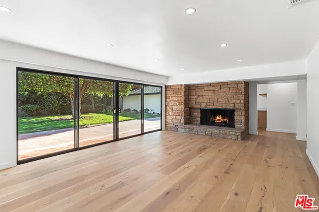 a view of empty room with wooden floor and fireplace