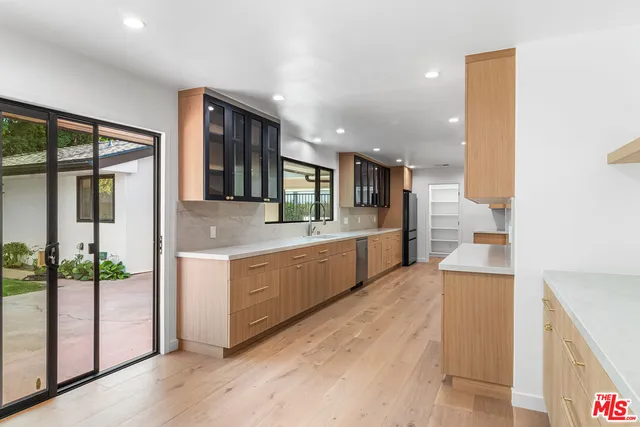 a large kitchen with a large counter top and stainless steel appliances