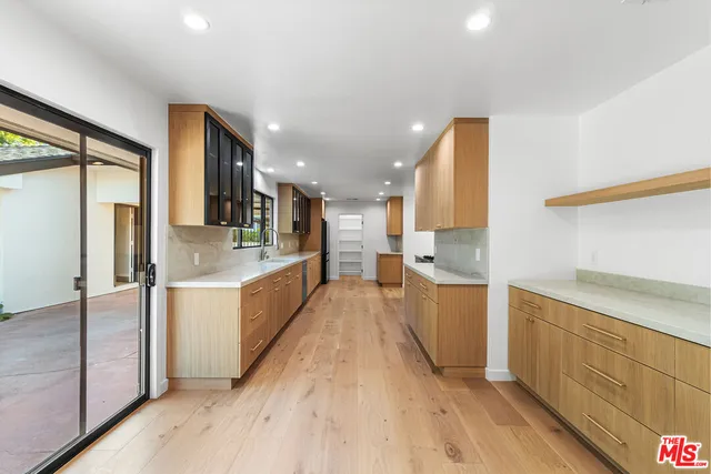 a large kitchen with a lot of counter space and stainless steel appliances