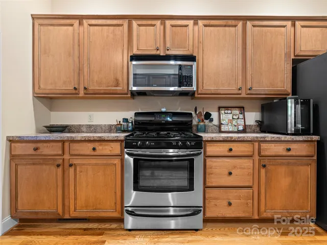 a kitchen with granite countertop a stove and a microwave