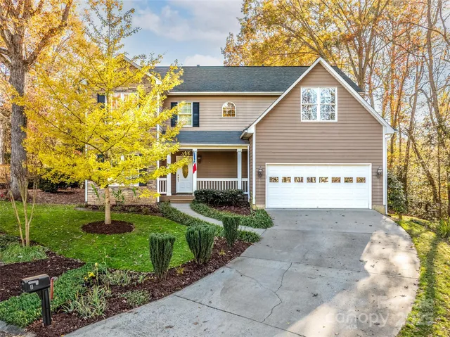 a view of a house with backyard and trees