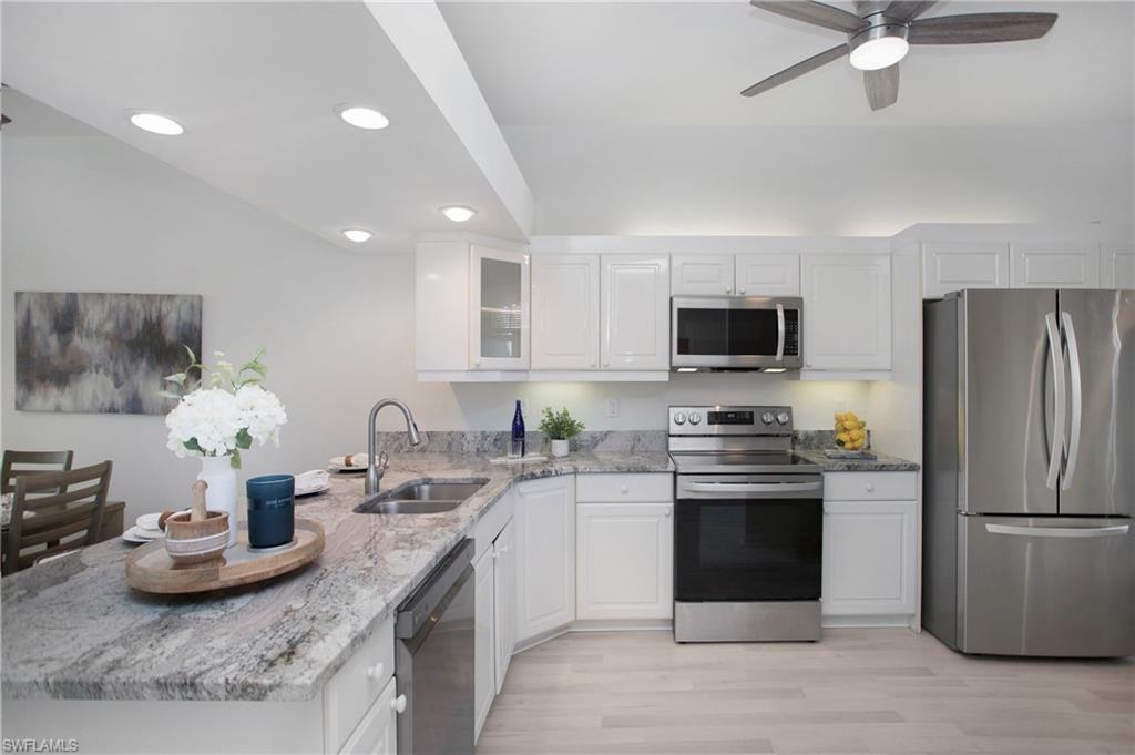 14560 Red Fox Run, Unit 515 Naples, FL 34110 - Photo 11 of 33 a kitchen with stainless steel appliances granite countertop a sink and a stove
