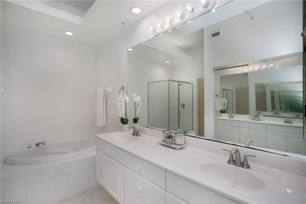 14560 Red Fox Run, Unit 515 Naples, FL 34110 - Photo 15 of 33 a bathroom with a double vanity sink a mirror and a bathtub