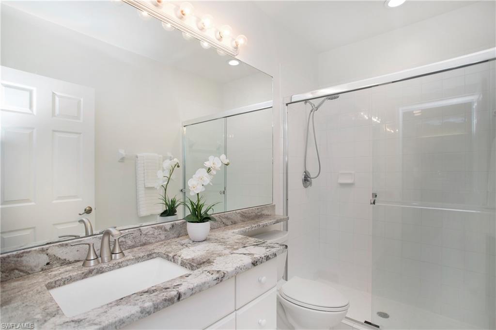 14560 Red Fox Run, Unit 515 Naples, FL 34110 - Photo 19 of 33 a bathroom with a granite countertop sink toilet and shower