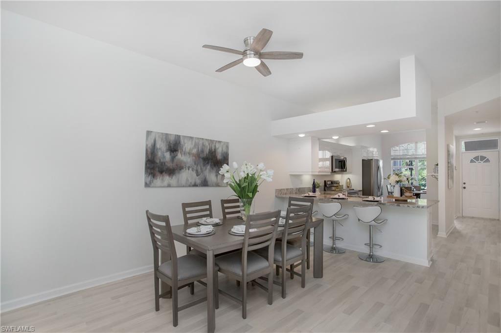 14560 Red Fox Run, Unit 515 Naples, FL 34110 - Photo 9 of 33 a view of a dining room with furniture and a chandelier
