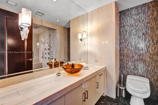 a view of a hallway with wooden floor and a bathroom