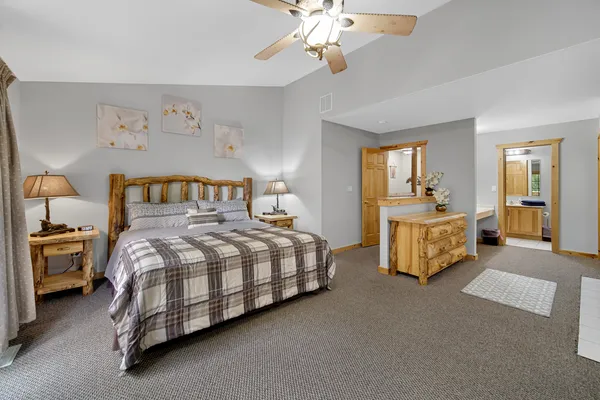 a spacious bedroom with a bed and a chandelier
