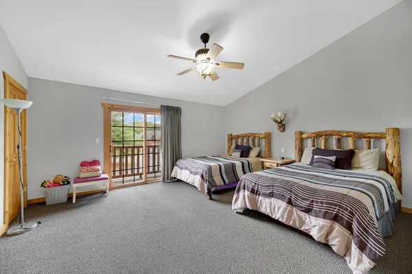 a spacious bedroom with a bed and a chandelier