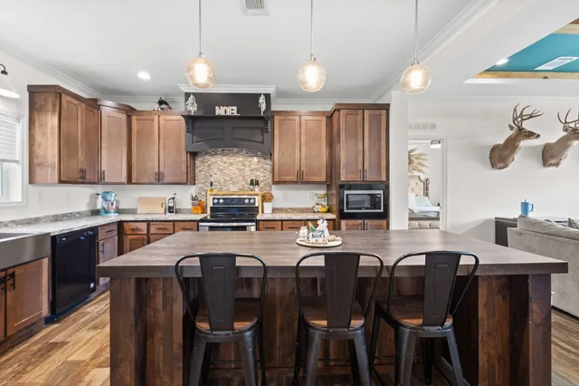 a kitchen with granite countertop a sink counter top space and stainless steel appliances