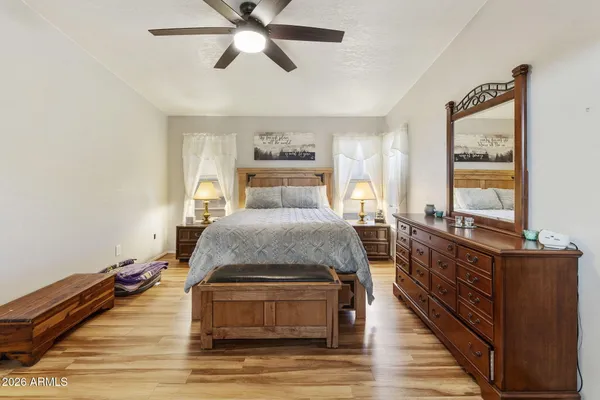 a spacious bedroom with a bed and wooden floor