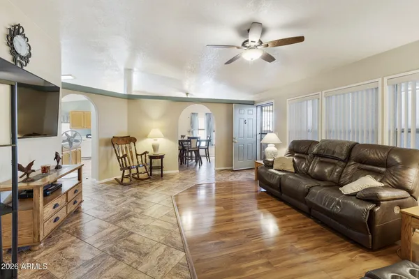 a living room with furniture and a flat screen tv with wooden floor