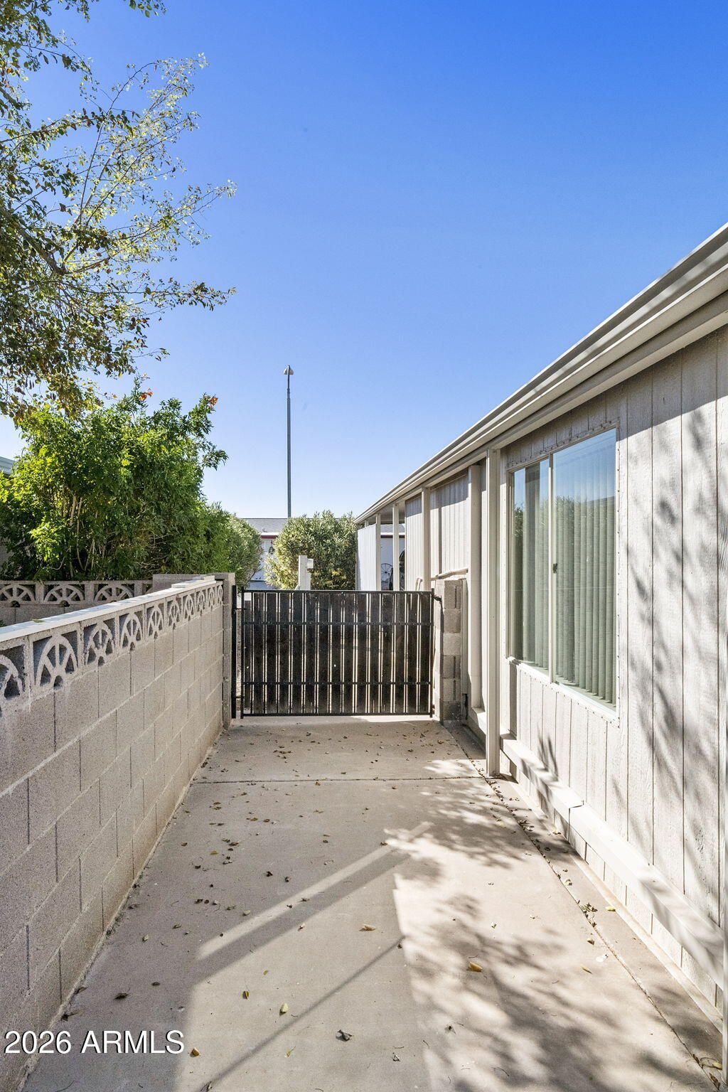 3700 South Tomahawk Road, Unit 23 Apache Junction, AZ 85119 - Photo 25 of 31 a view of a house with a small yard and wooden fence