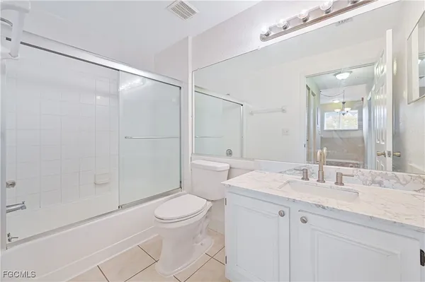 a bathroom with a granite countertop sink a toilet and shower