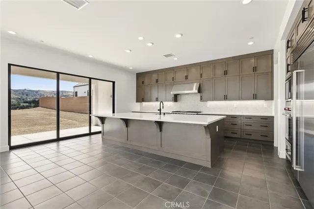 a kitchen with stainless steel appliances a sink cabinets and a large window