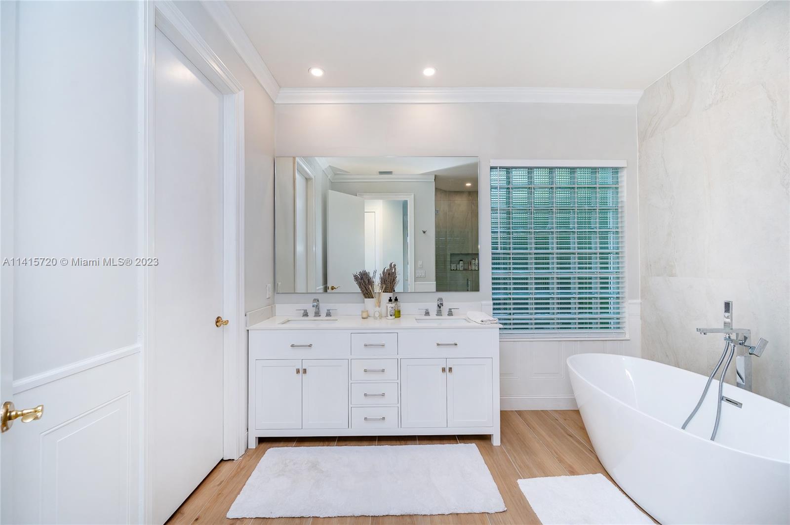 4167 Briarcliff Circle Boca Raton, FL 33496 - Photo 25 of 56 a spacious bathroom with a double vanity sink a mirror and a bathtub