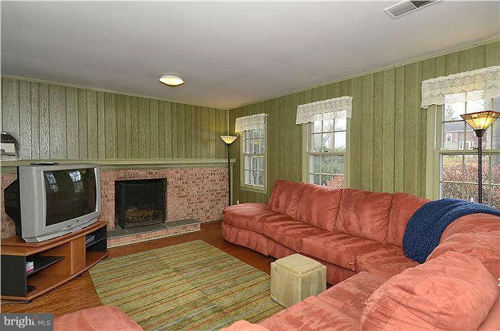 17205 Hoskinson Road Poolesville, MD 20837 - Photo 22 of 23 a living room with a couch a fireplace a flat screen tv and island