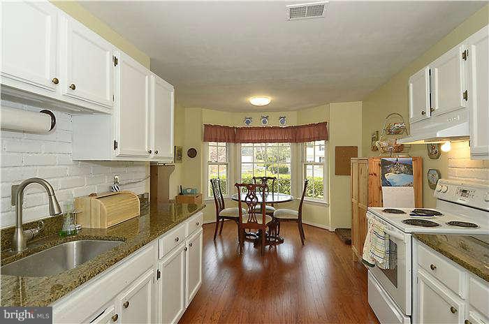 17205 Hoskinson Road Poolesville, MD 20837 - Photo 4 of 23 a kitchen with granite countertop a stove a sink a refrigerator and wooden cabinets