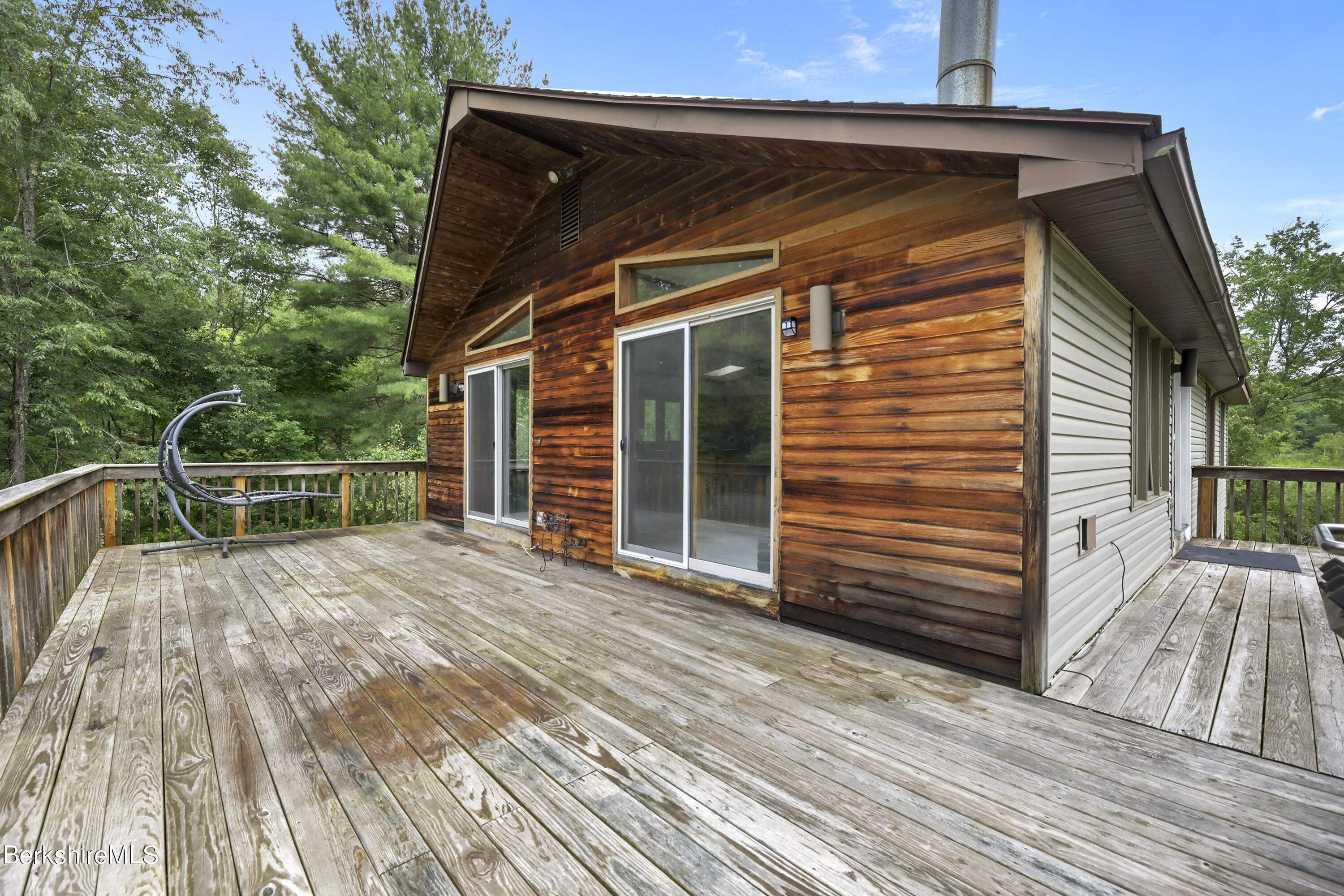 77 Shawnee Shore Road Becket, MA 01223 - Photo 20 of 28 a view of backyard with small cabin and wooden floor