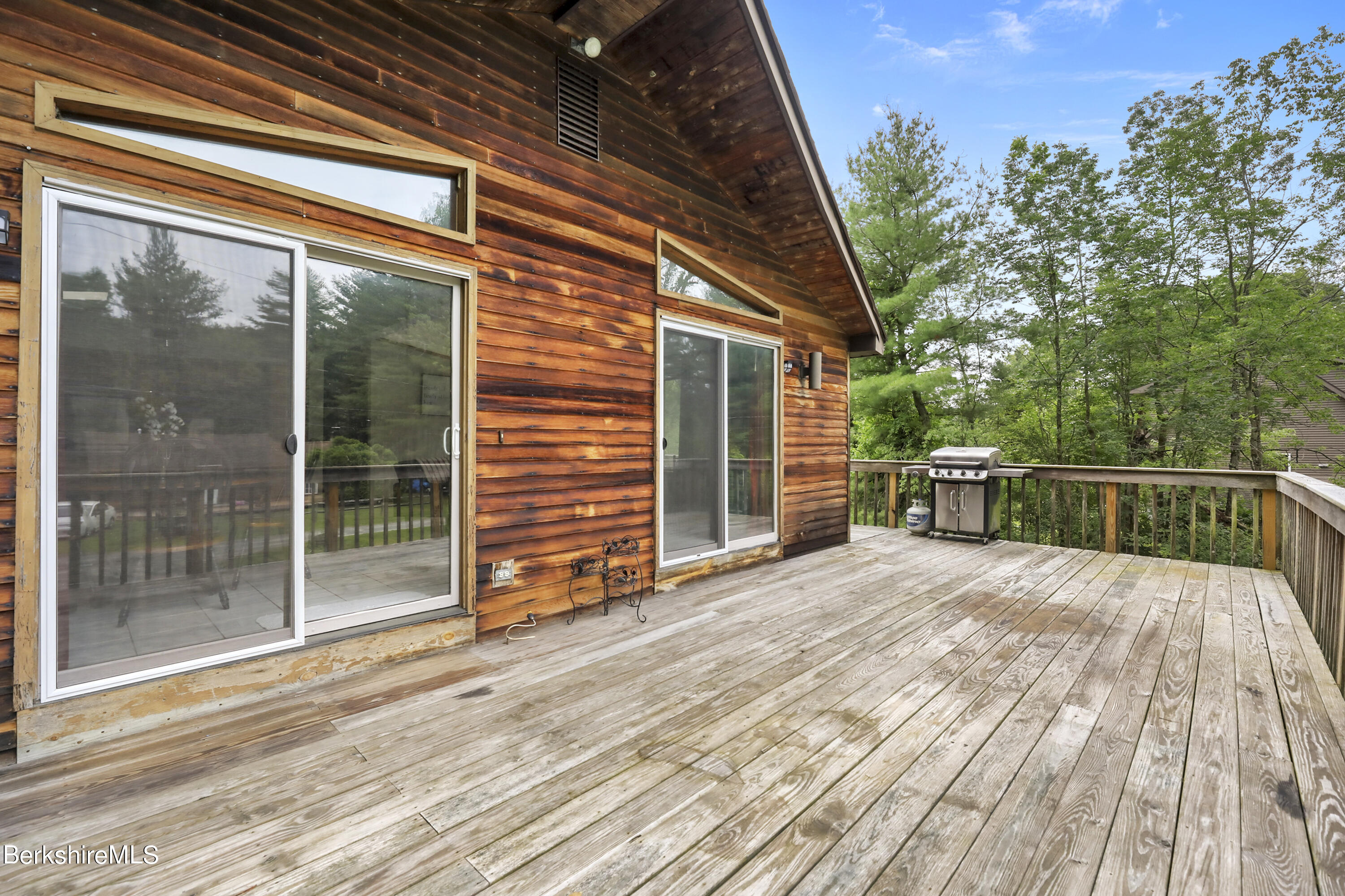 77 Shawnee Shore Road Becket, MA 01223 - Photo 21 of 28 a view of backyard with large trees and wooden floor