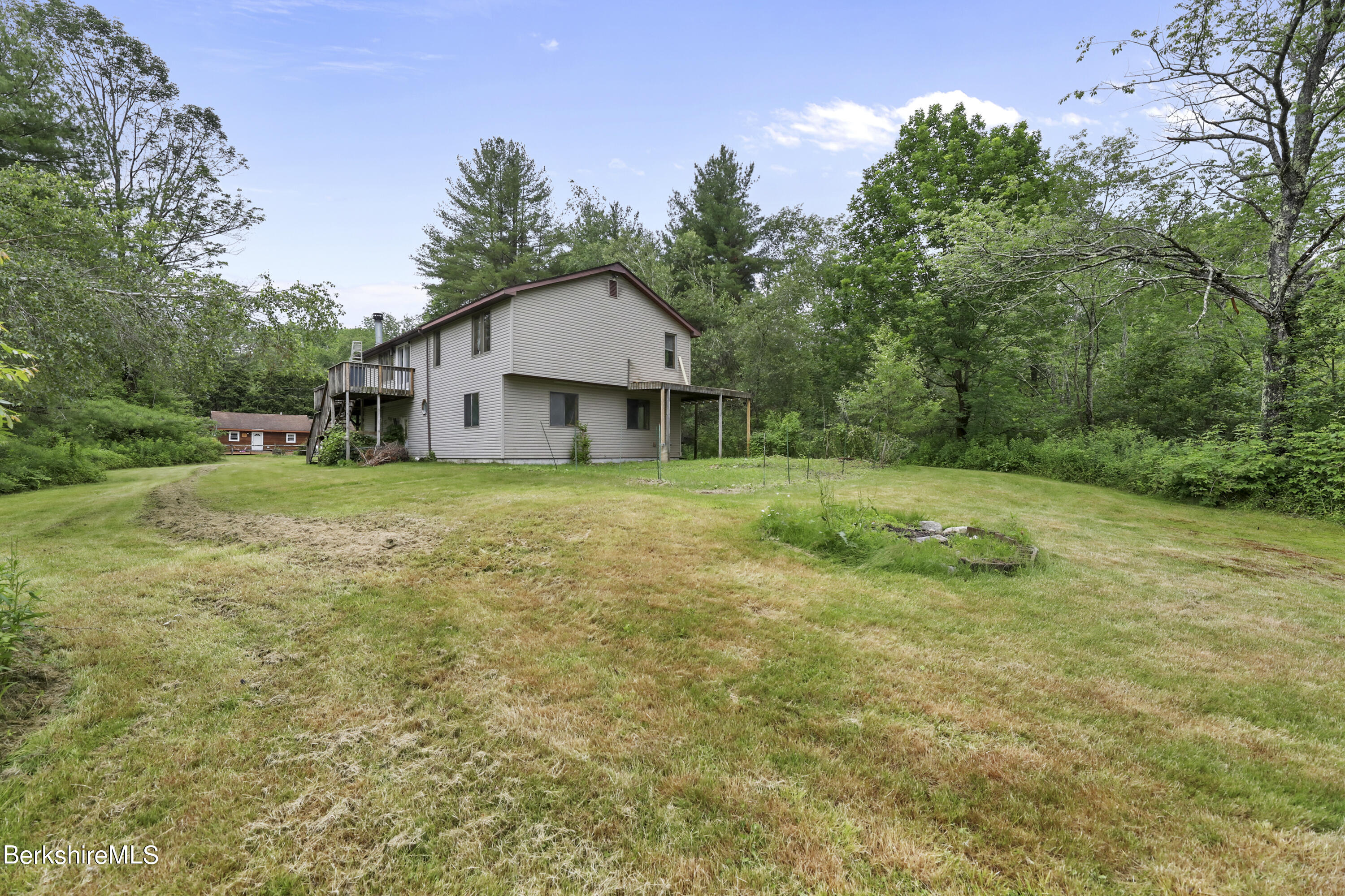 77 Shawnee Shore Road Becket, MA 01223 - Photo 25 of 28 a view of a house with a yard and sitting area