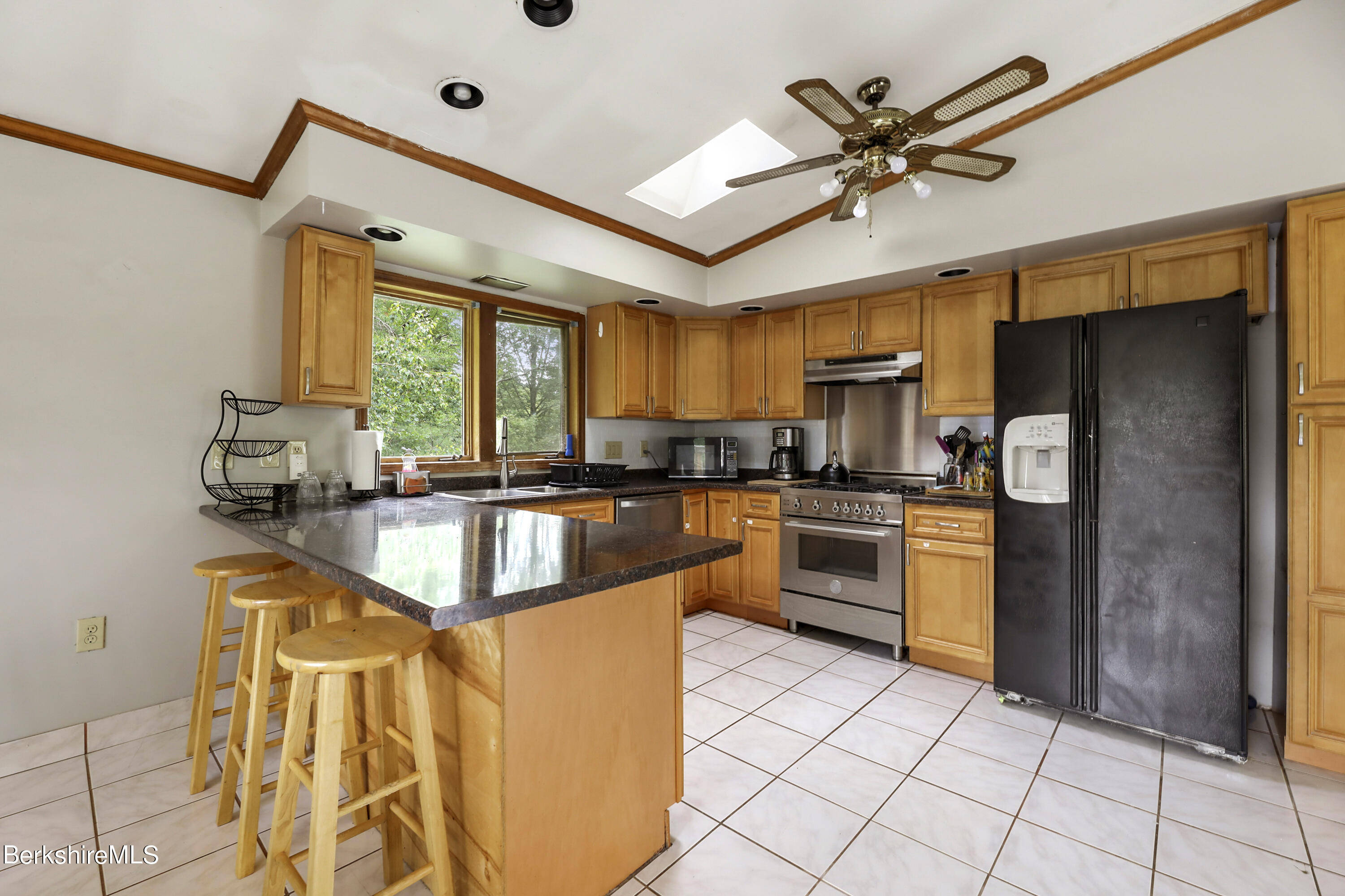 77 Shawnee Shore Road Becket, MA 01223 - Photo 8 of 28 a kitchen with stainless steel appliances granite countertop a refrigerator a sink a stove and white cabinets