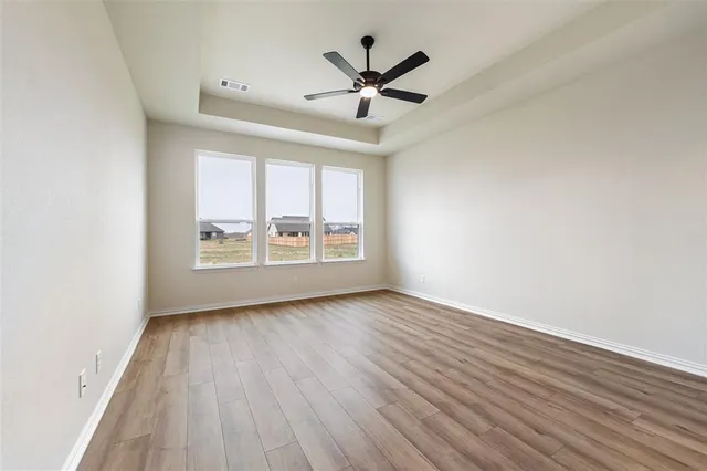 a view of empty room with wooden floor