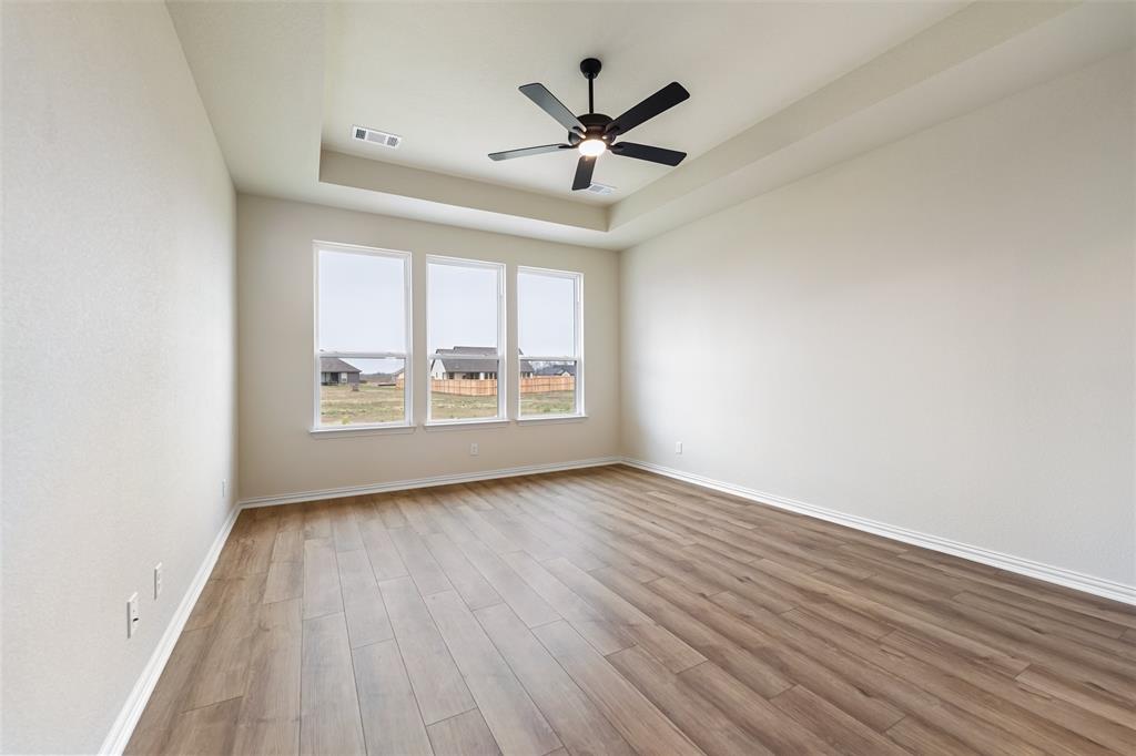 3107 White Oak Road Terrell, TX 75161 - Photo 24 of 40 an empty room with wooden floor ceiling fan and windows